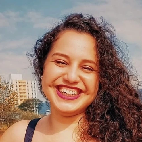 Fotografia de Camila Lourenço Covre sorrindo ao ar livre